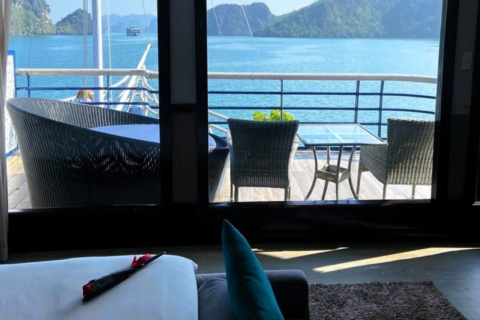 A cabin window seat and balcony chairs with a view of limestone islands.