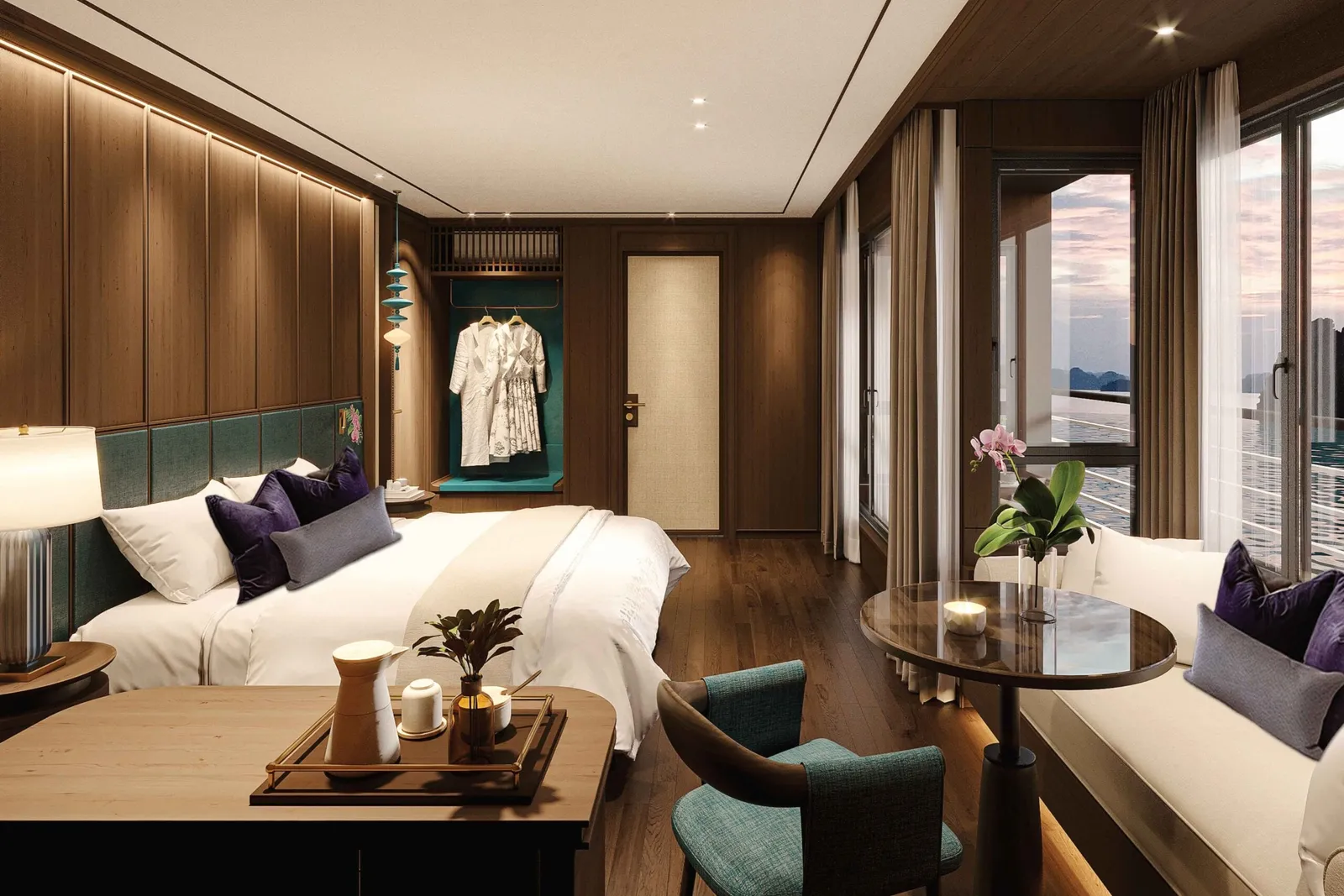 A luxury cabin interior with a bed, seating area, and large windows showing water and karst mountains at sunset.
