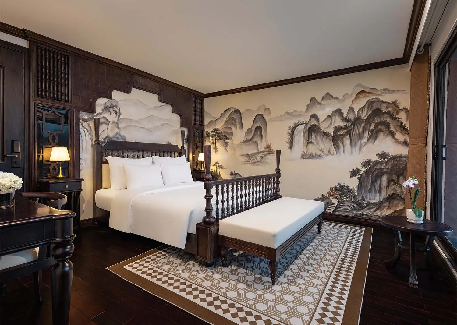 A luxury cabin bedroom with a four-poster bed, dark wood paneling, patterned rug, and a large Chinese ink-wash landscape mural on the wall.